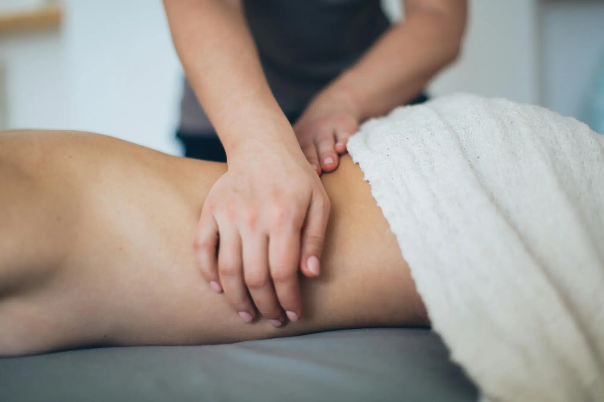 Body massage with steady touch on a treatment table