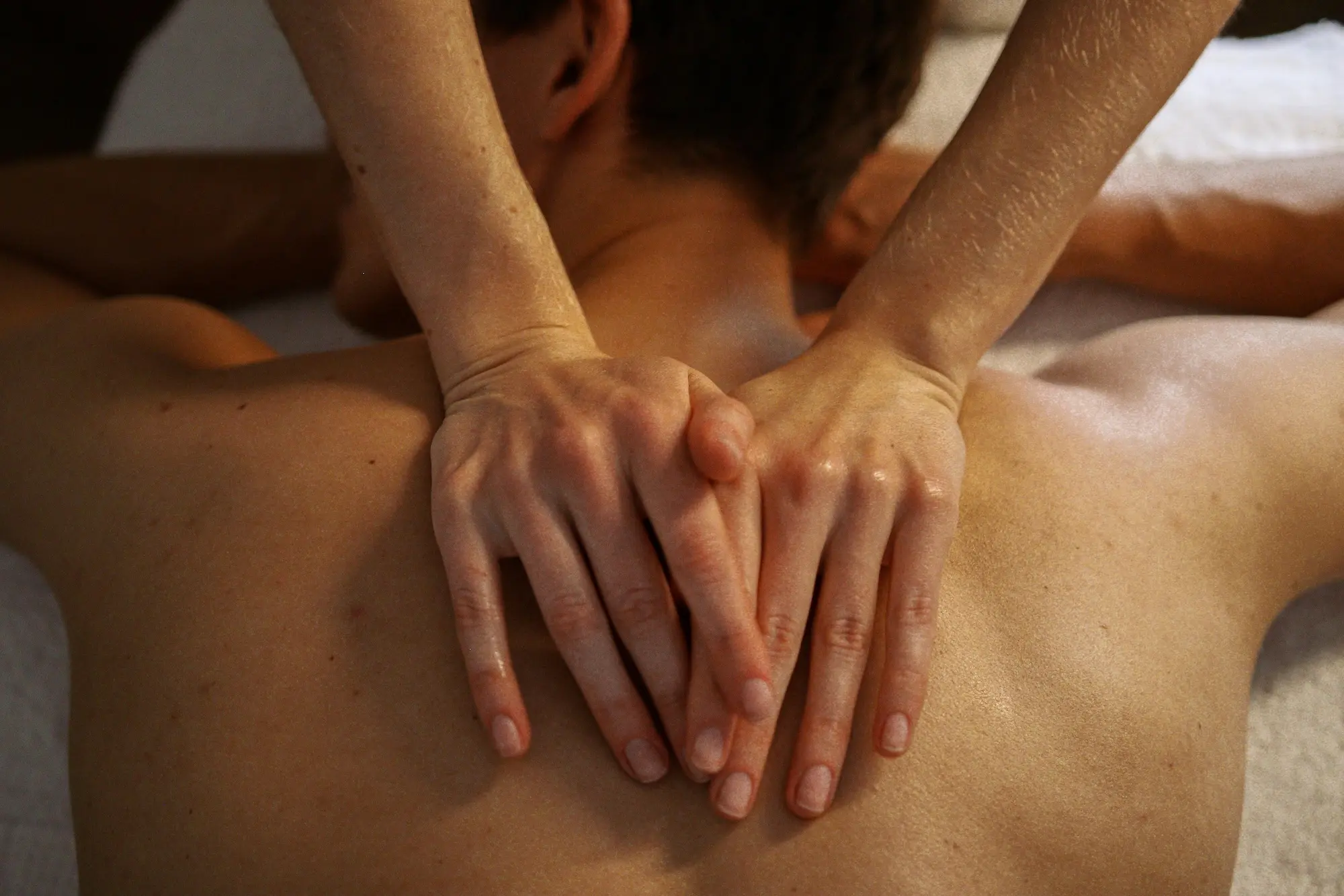Hands performing sensual massage with warm oil